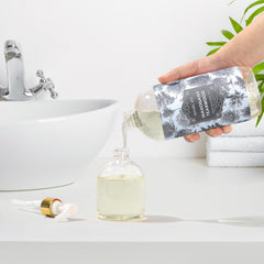 ROMIIE ZOI by bathroom sink styled to show gentle cleansing and fragrance