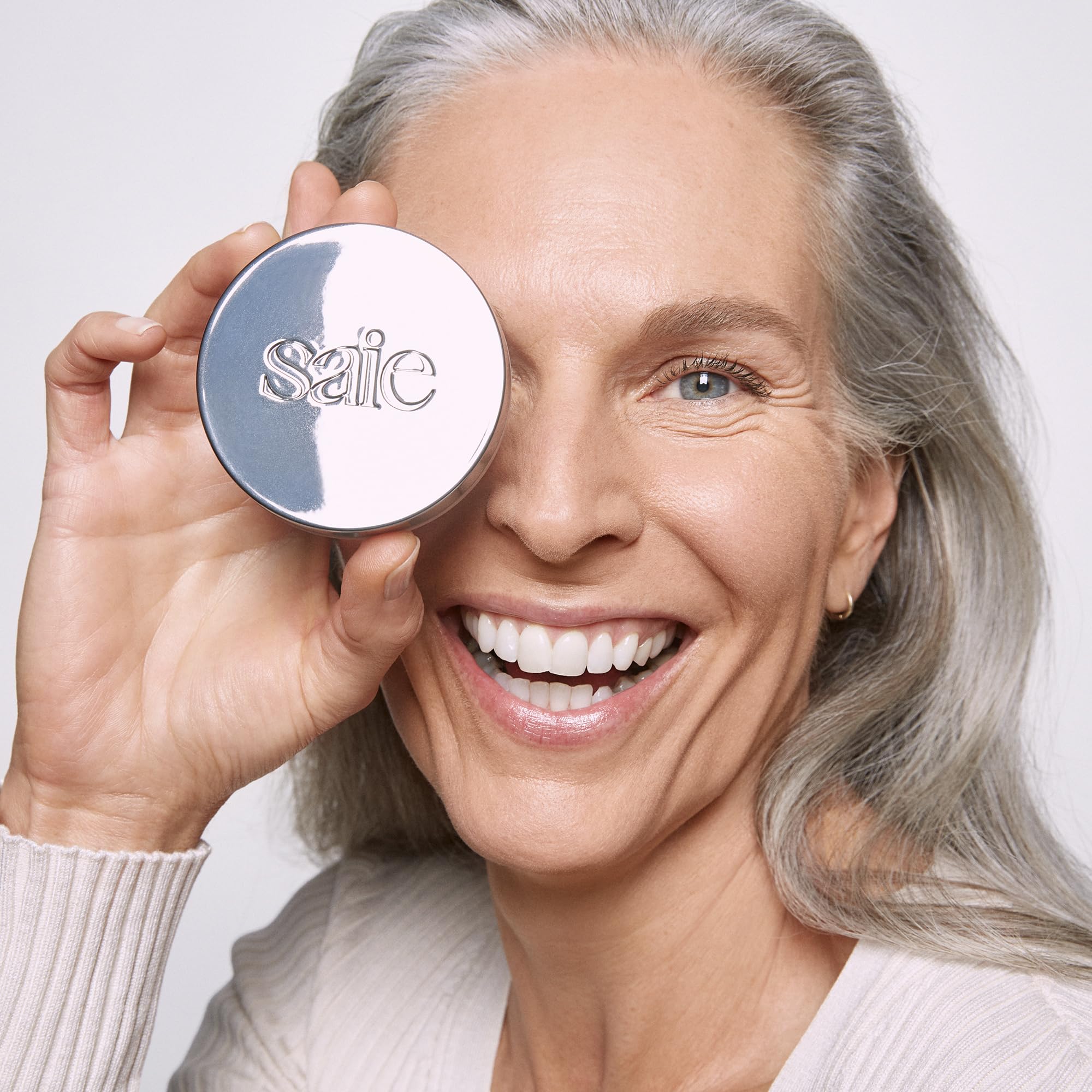 Saie compact next to common object showing 0.14 oz travel-friendly size