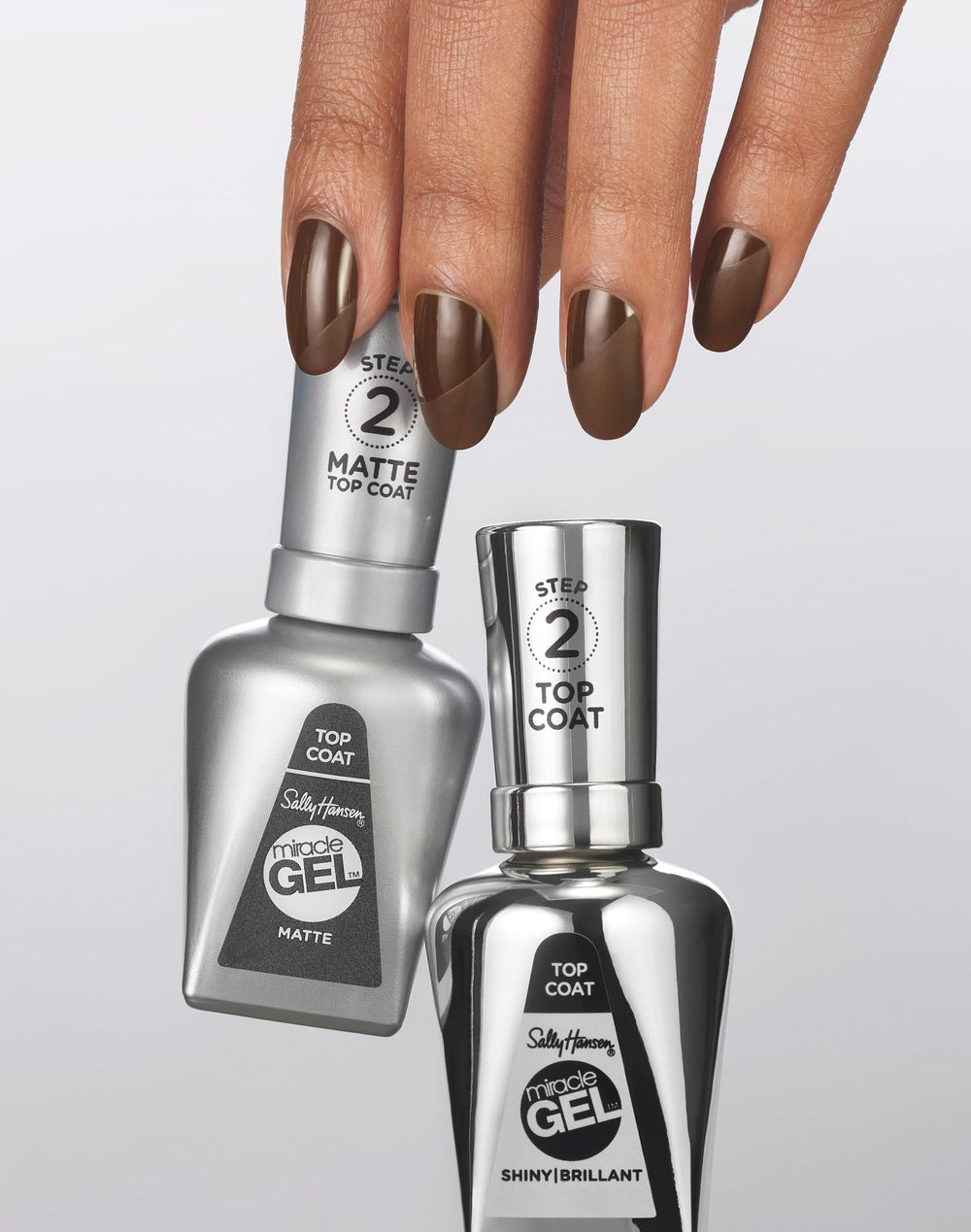 Sally Hansen bottle in hand for scale illustrating compact size and travel ready