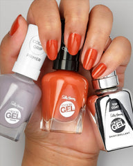 Polish bottle beside a coin to show scale of Sally Hansen bottle for travel-friendly size