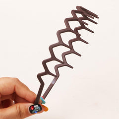SHE LIAN headband beside a hand to show average size for most adult heads