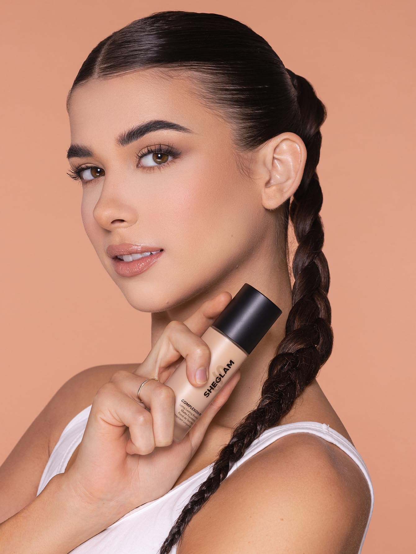 SHEGLAM bottle held in hand showing product scale and travel convenience
