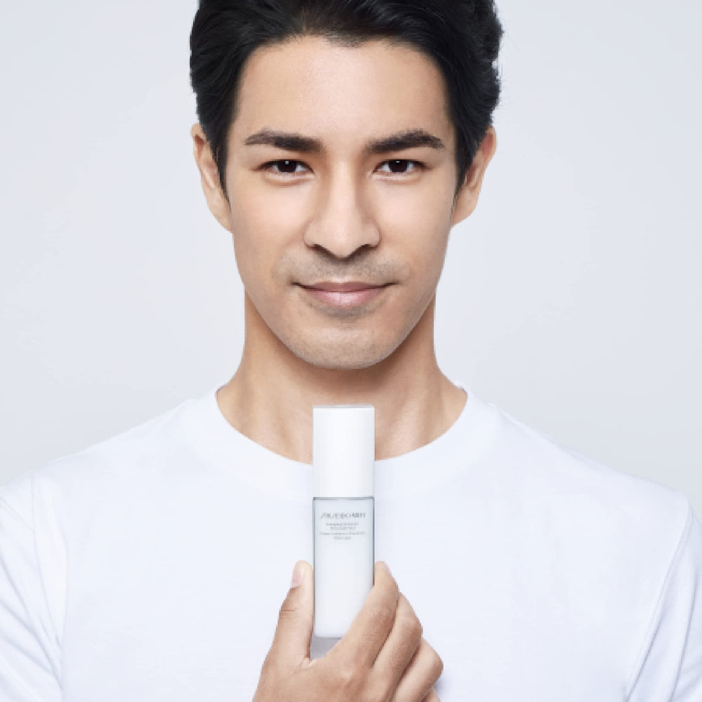 Shiseido bottle beside a smartphone for size comparison and portability