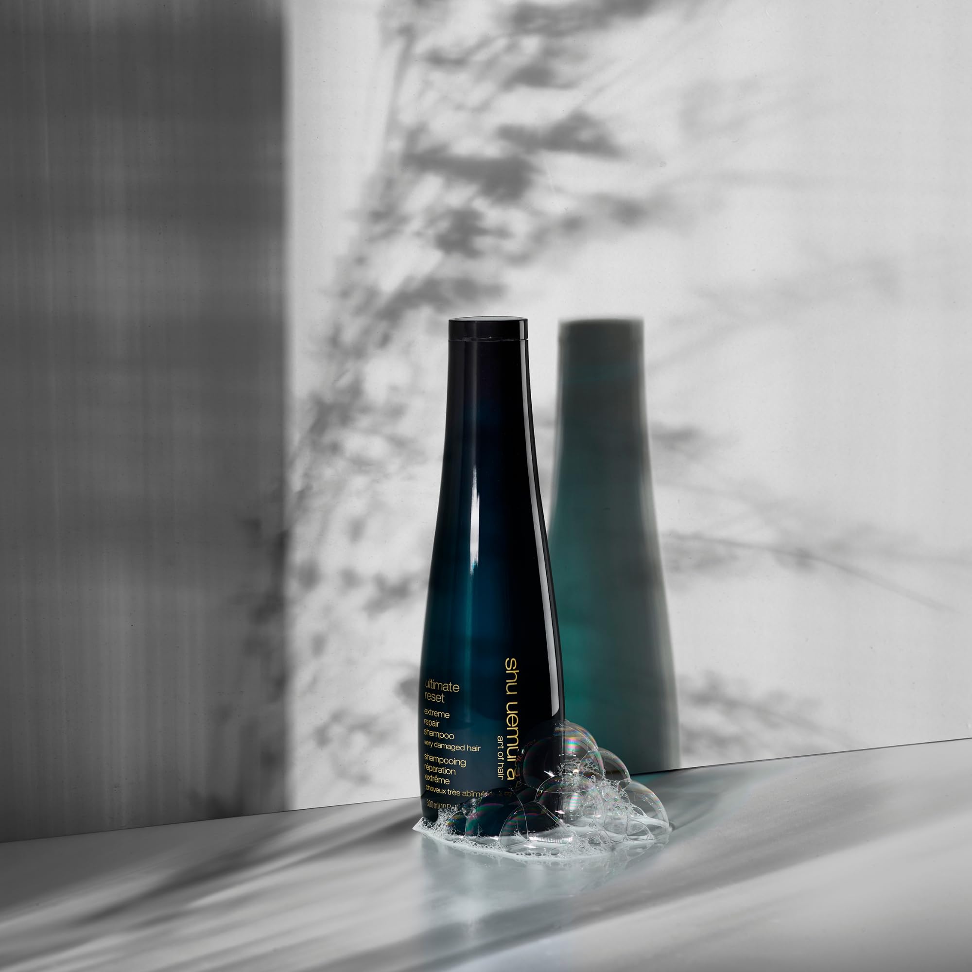 shu uemura on shower shelf in bathroom lifestyle suggesting daily use