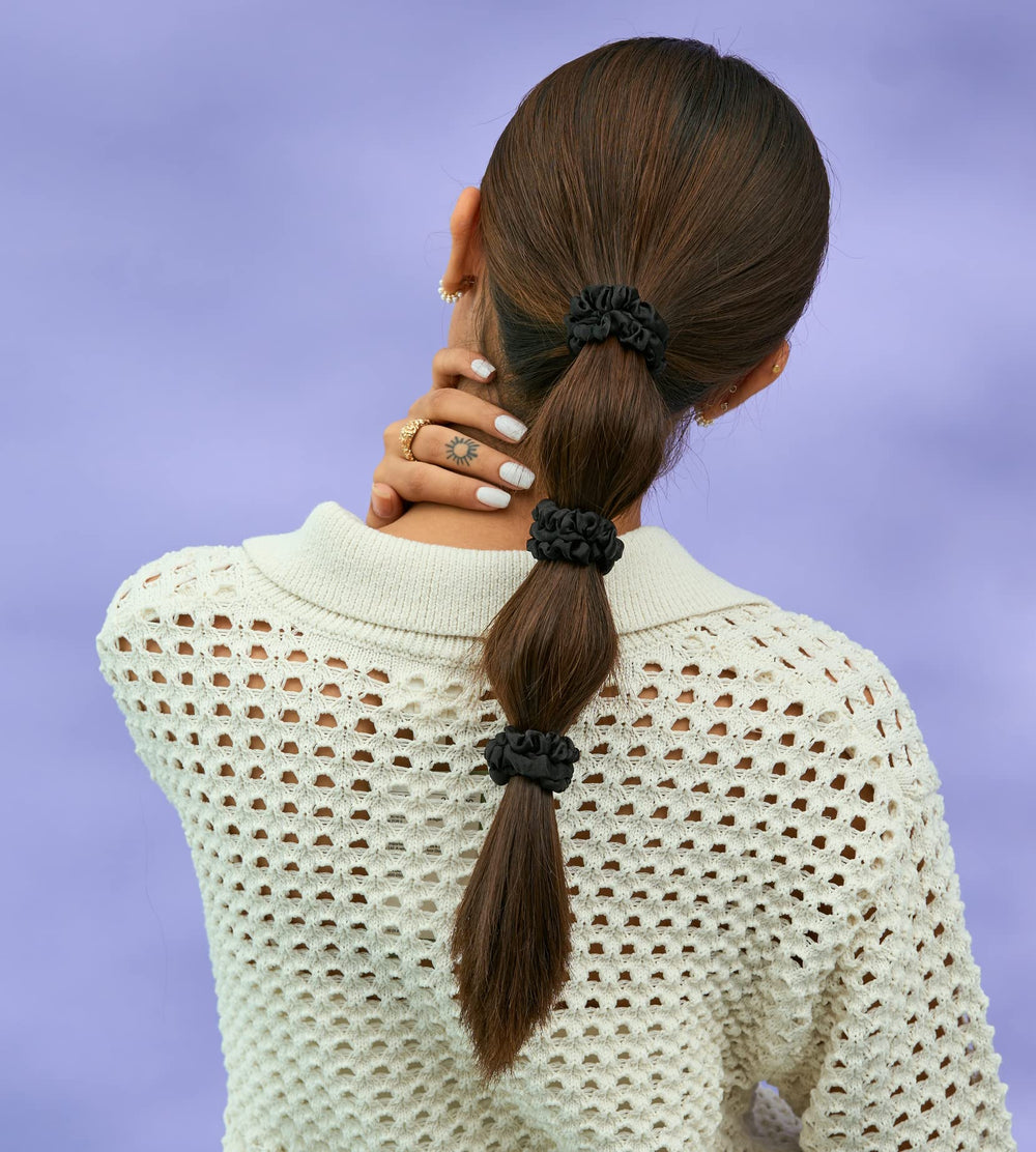 Silvr Bear scrunchie next to coin for scale showing skinny profile and discreet fit benefit