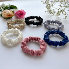 Silvr Bear scrunchie beside a coin to show compact size and travel readiness