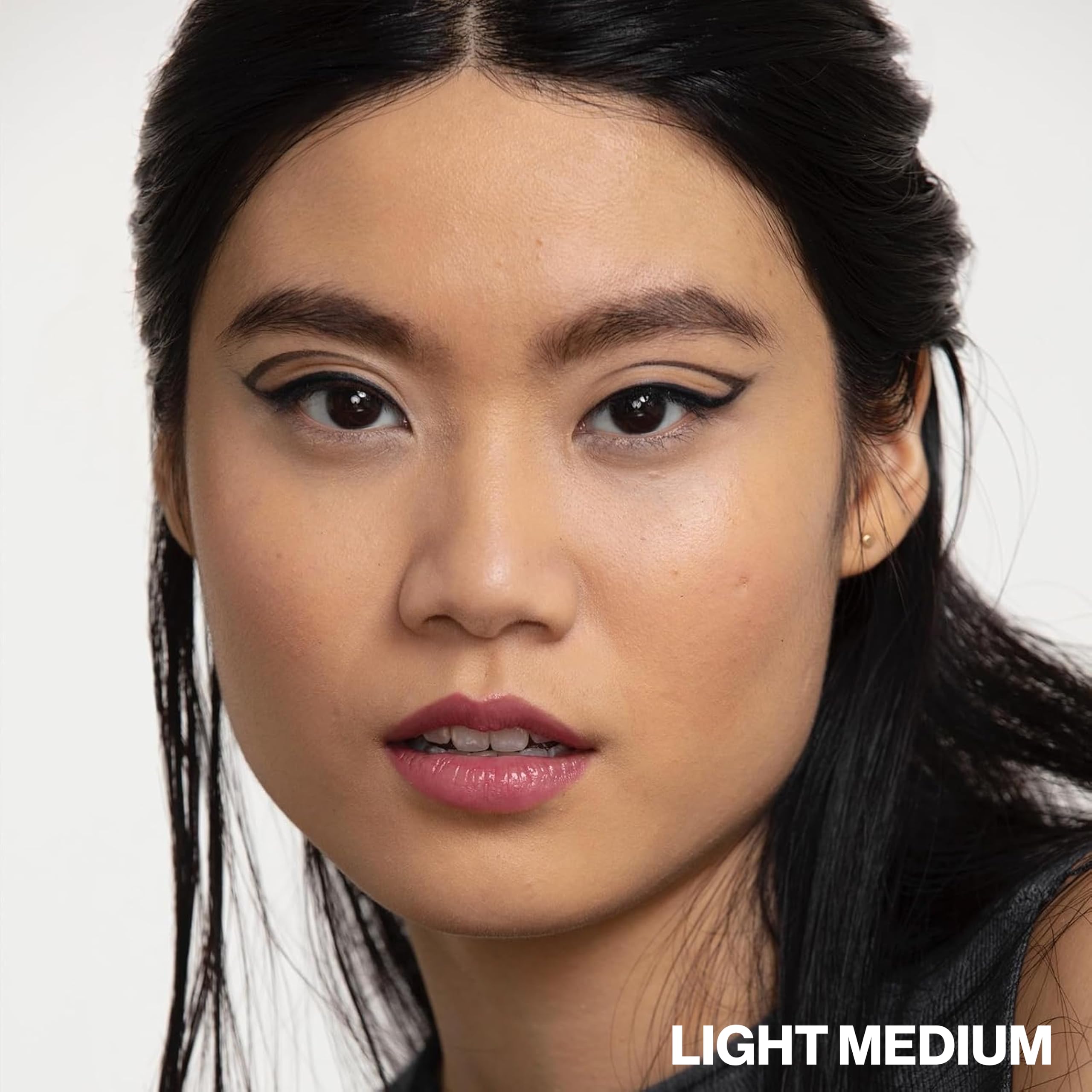 Smashbox model outdoors with dewy skin demonstrating sun protection and radiance benefit
