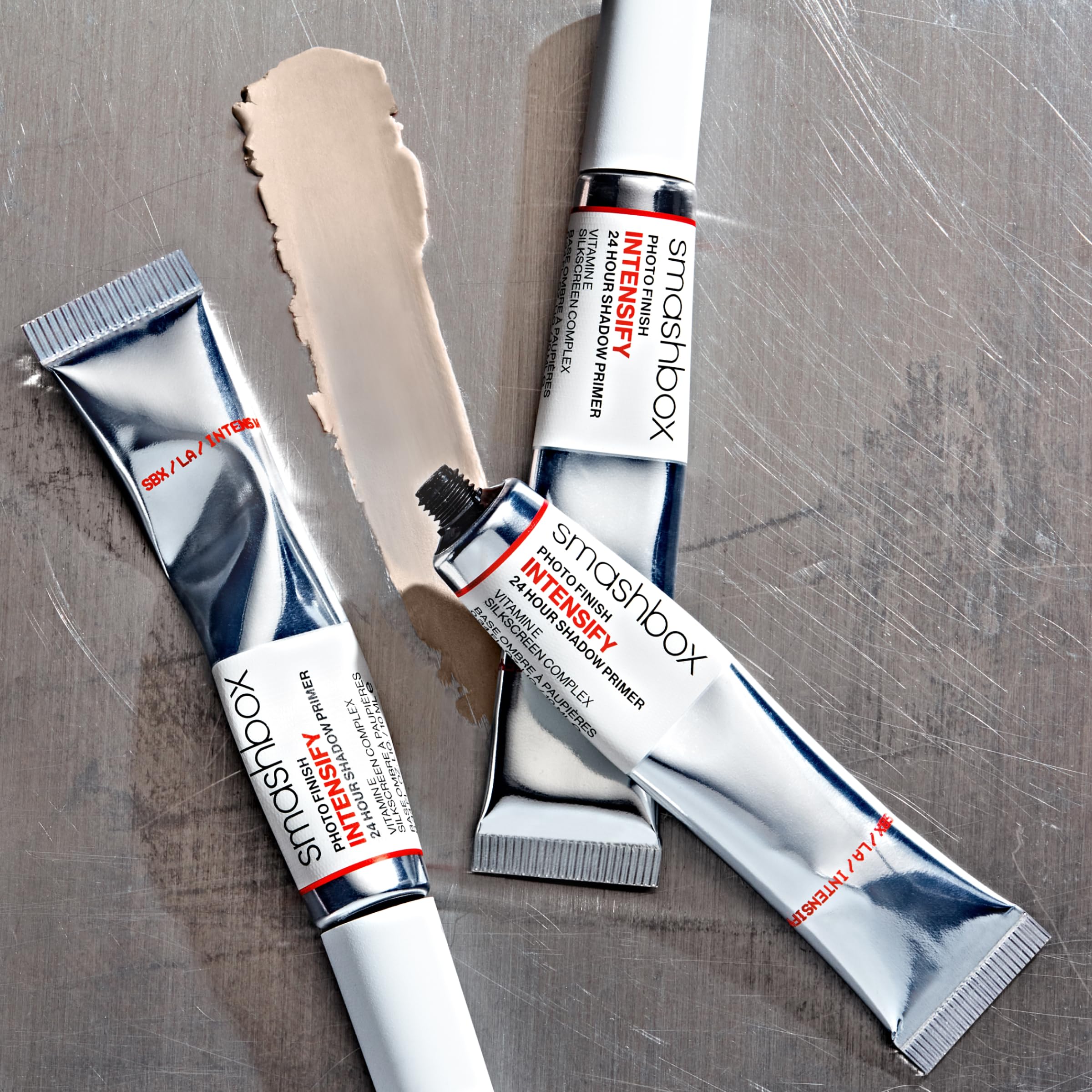 Smashbox primer size comparison next to makeup brush to show compact travel-friendly volume