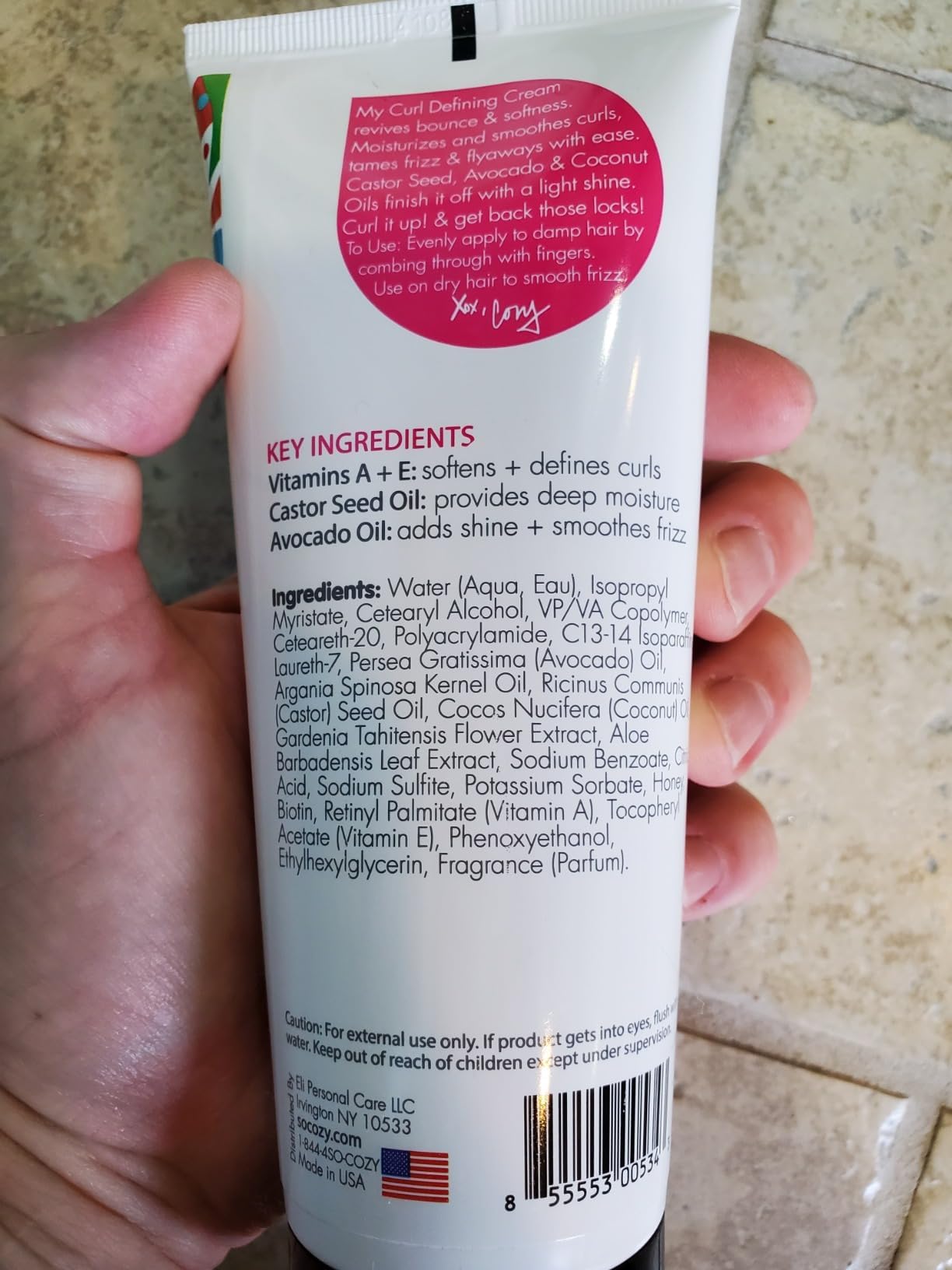 Child applying SoCozy cream to curls demonstrates gentle styling and frizz control benefit