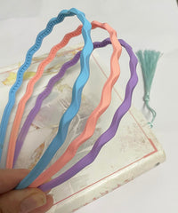 Springtime headband held in hand to show size scale and easy portability benefit