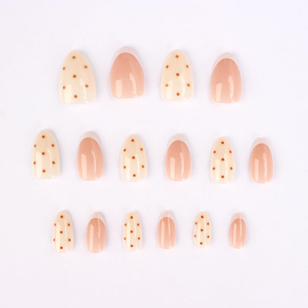 Stbisen close-up of white French tip and brown dot detail highlighting modern design