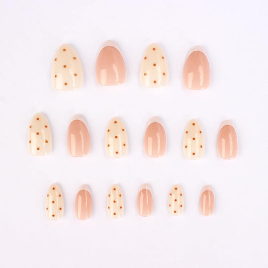 Stbisen close-up of white French tip and brown dot detail highlighting modern design