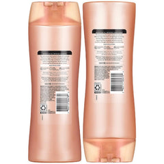 Suave bottles in hand for scale showing travel-friendly 12.6 oz benefit