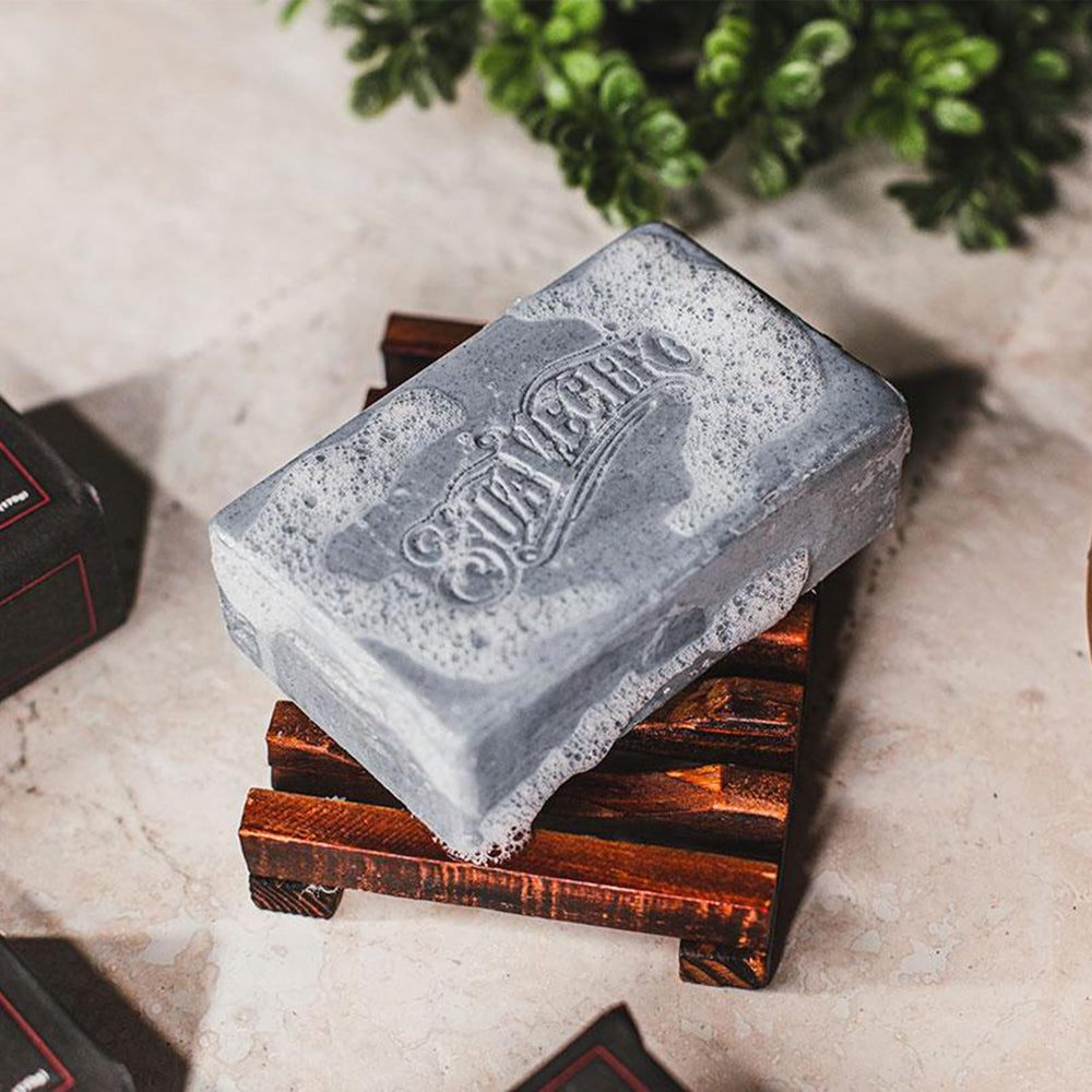 Suavecito bar on shower shelf with towel, portrays everyday grooming convenience