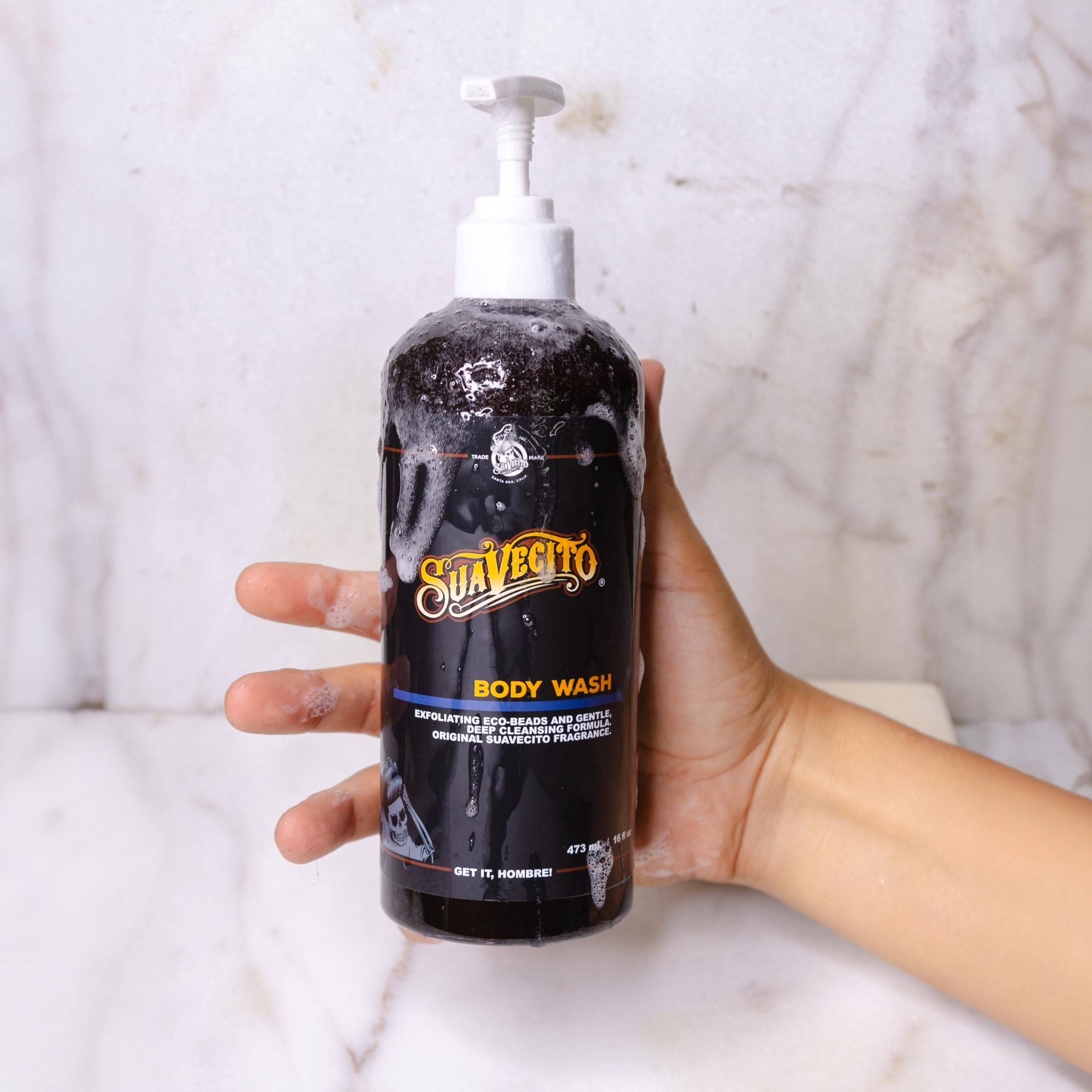 Suavecito bottle held in hand to show 16 oz scale and travel-friendly size