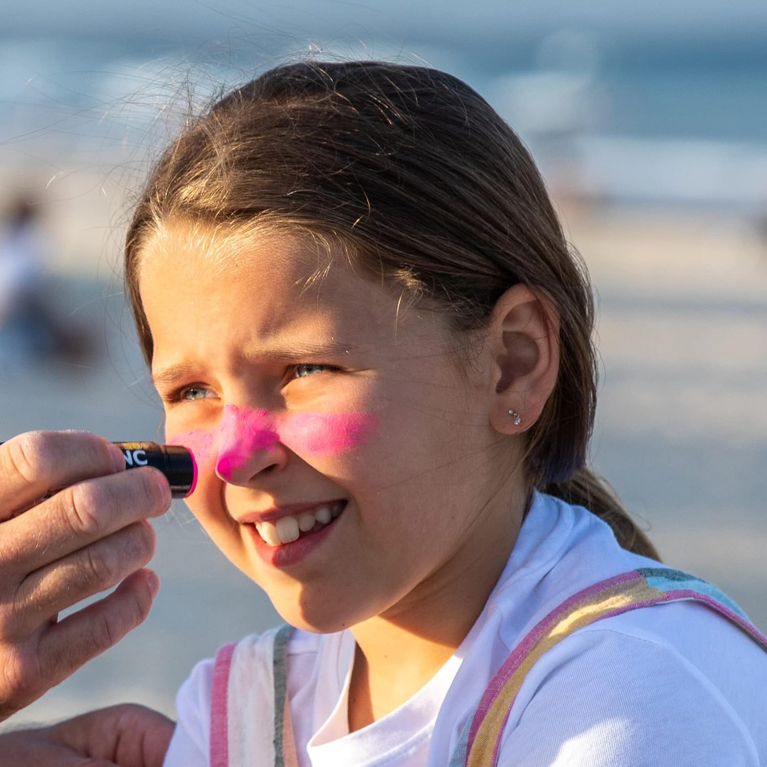 Sun Zapper being applied to a child’s cheek showing visible coverage benefit