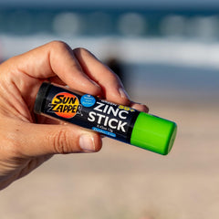 Sun Zapper 12g stick beside a passport to show travel-friendly size