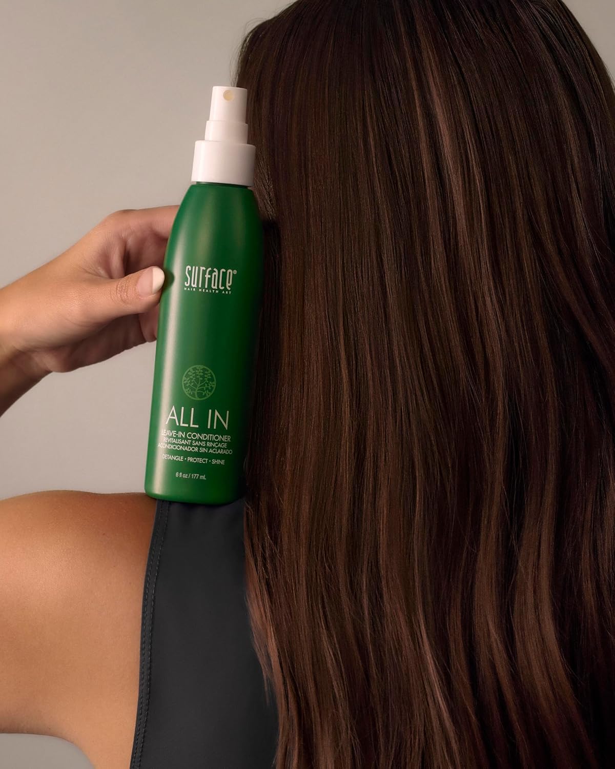 SURFACE bottle held in hand to show 6 fl oz scale and easy pump usability