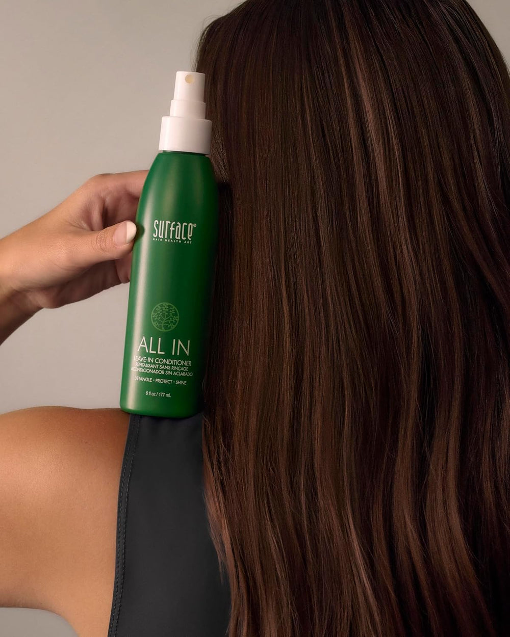 SURFACE bottle held in hand to show 6 fl oz scale and easy pump usability