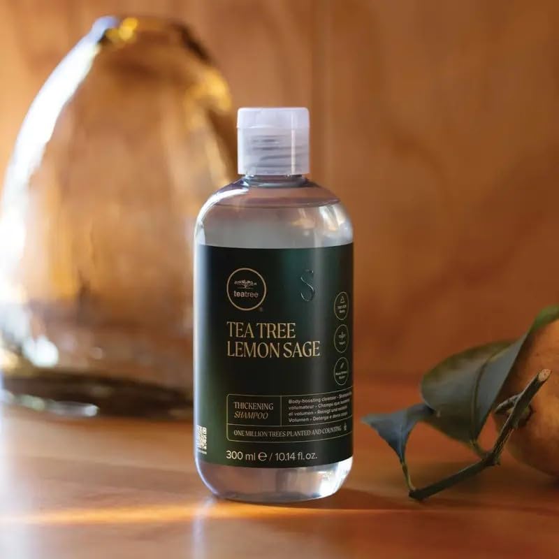 Tea Tree bottle beside a coin and travel items to show compact 2.5 fl oz size for trips