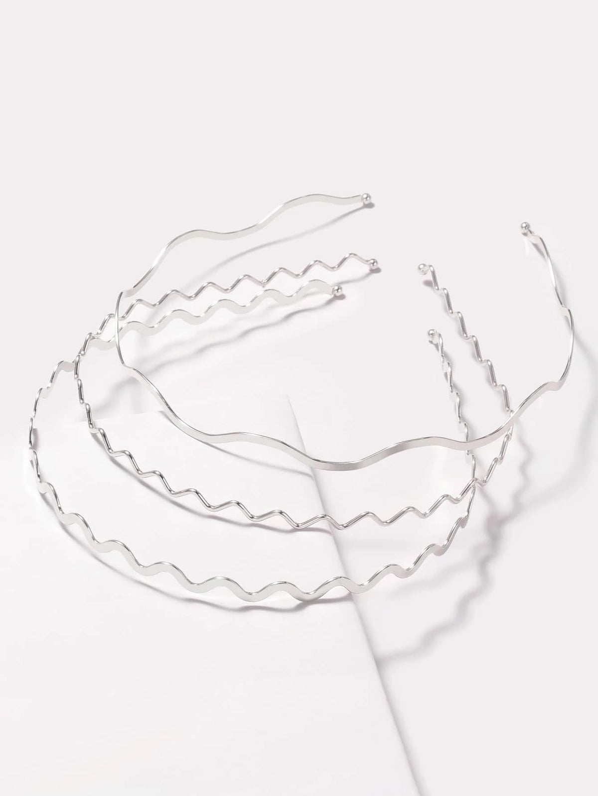 TEBIEKOY front view of three silver wavy headbands showing polished finish and versatility