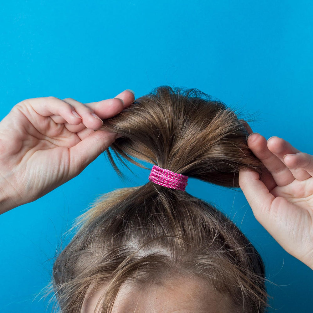 TecUnite glitter hair elastic securing a slim ponytail on dark hair, neat styling benefit