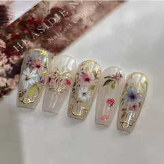 Teilihai manicured hand holding wildflowers illustrating natural boho styling benefit