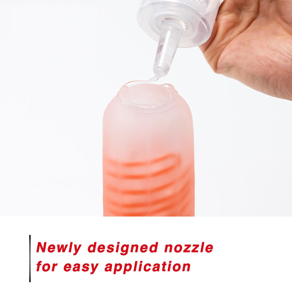 TENGA bottle in hand demonstrating ergonomic squeeze design for controlled dispensing