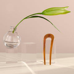 The Hair Edit pin held in hand to show extra-large scale for thick hair support
