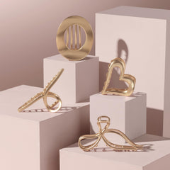 The Hair Edit heart clip next to hand for scale showing medium size benefit: easy to hold