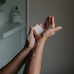 The Unscented Company shampoo bar on bathroom shelf suggesting low-waste routine