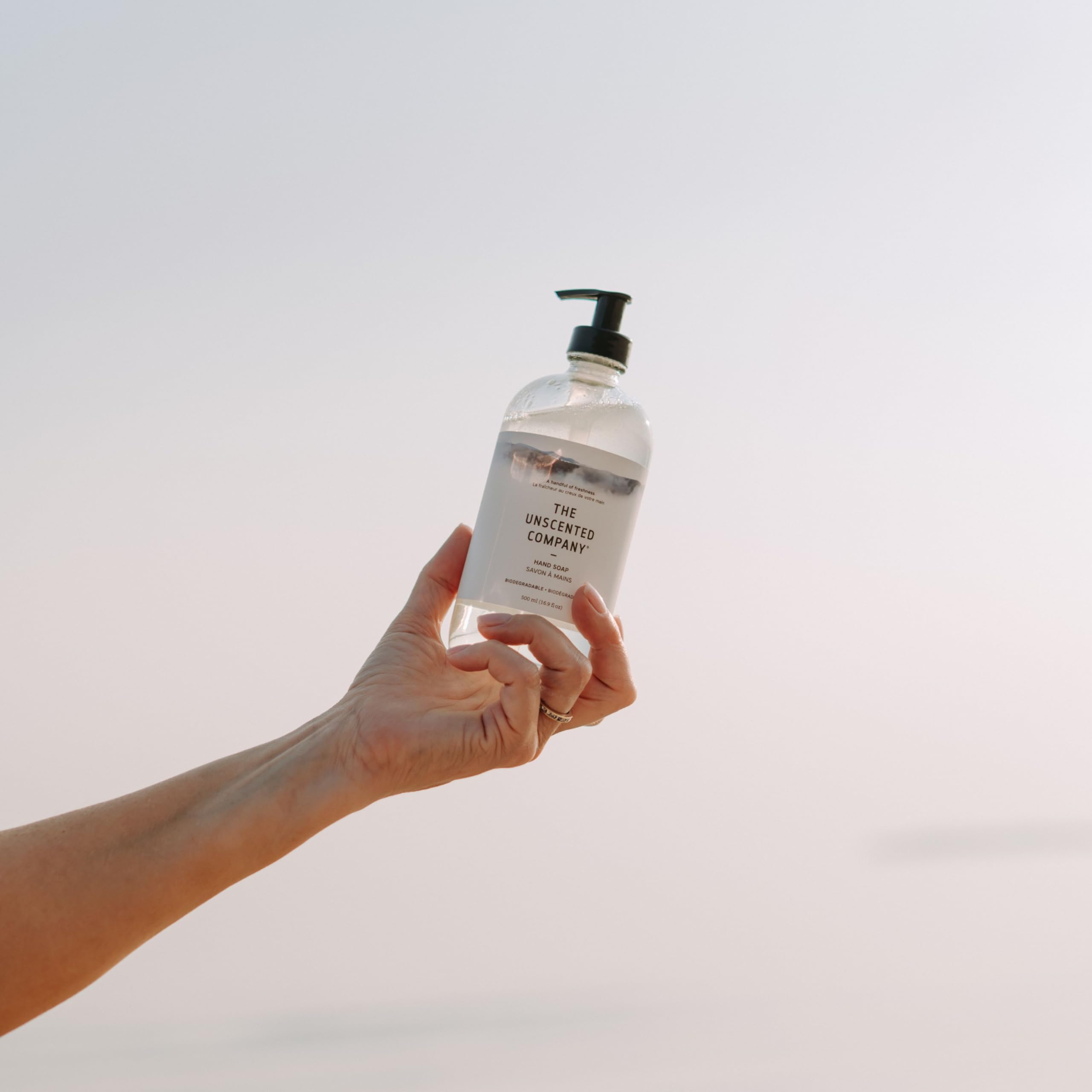 The Unscented Company bottle beside a refill jug showing scale and refill option benefit: reduces single-use plastic