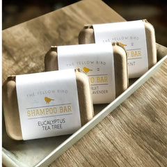 Argan and jojoba oils beside The Yellow Bird bar emphasizing hydration and shine
