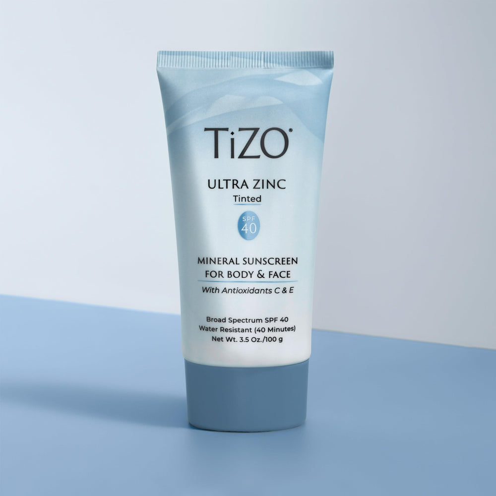 TIZO tube beside a hand for scale showing 3.5 oz size
