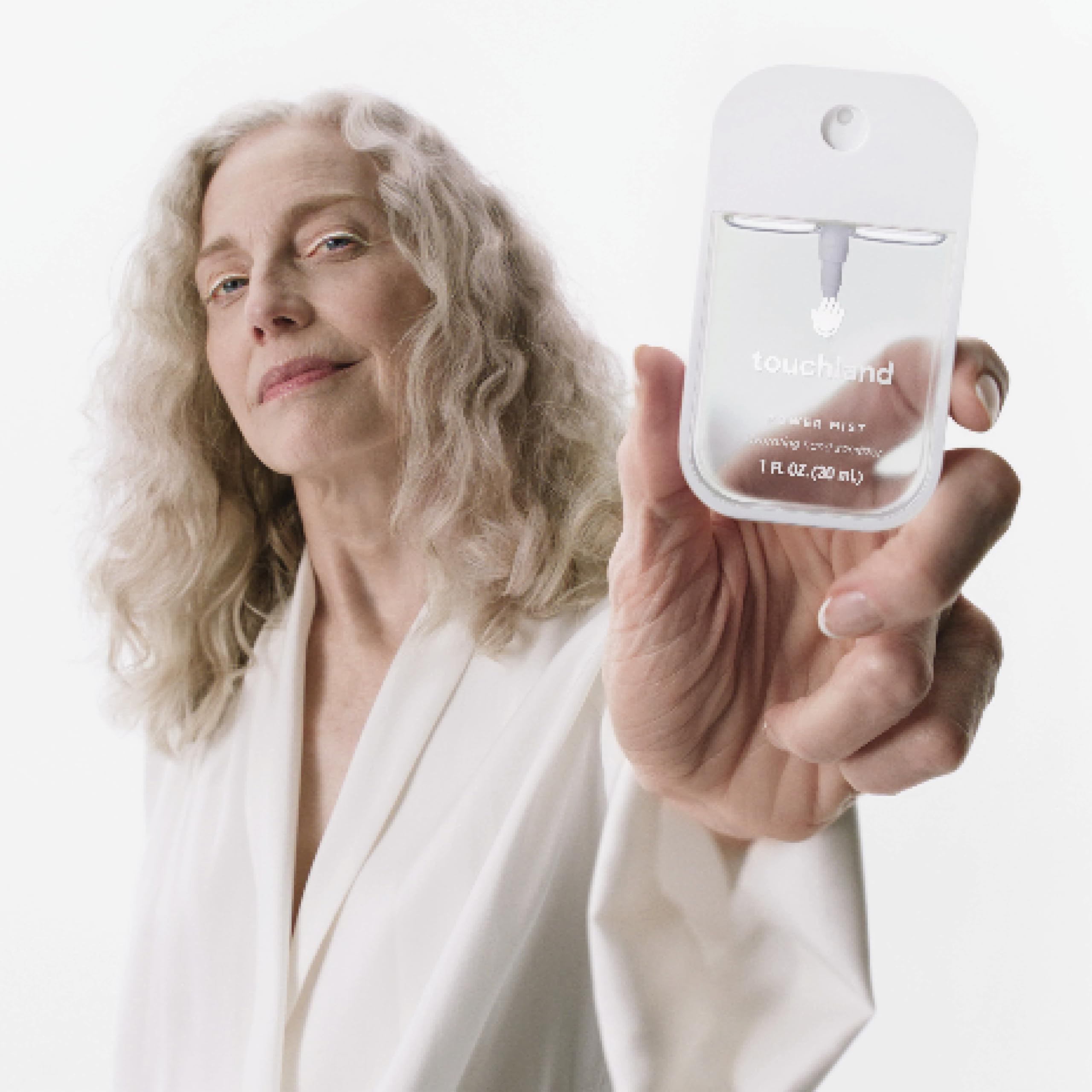 Touchland size comparison with coin showing 1 fl oz scale for carry convenience