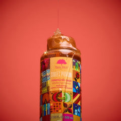 Tree Hut bottle next to hand showing 18 fl oz size and travel convenience