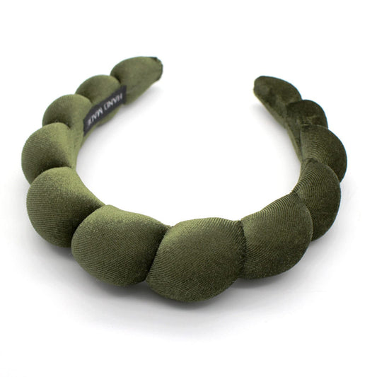 Uchyius headband front view showing leaf green velvet and polished look