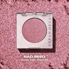 URBAN DECAY swatch of Bad Seed on forearm showing vibrant shimmer payoff
