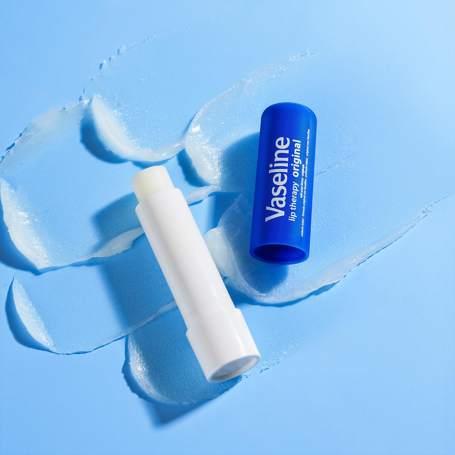 Vaseline sticks beside travel essentials showing portable lip care for on-the-go protection