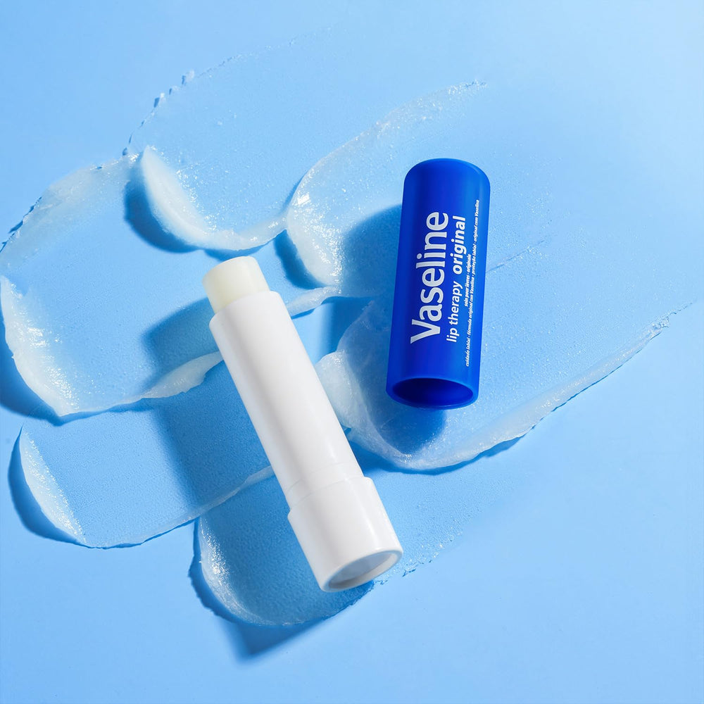 Vaseline sticks beside travel essentials showing portable lip care for on-the-go protection