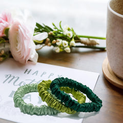 VLOMOT scrunchie beside coin to show slim size and discreet, lightweight benefit