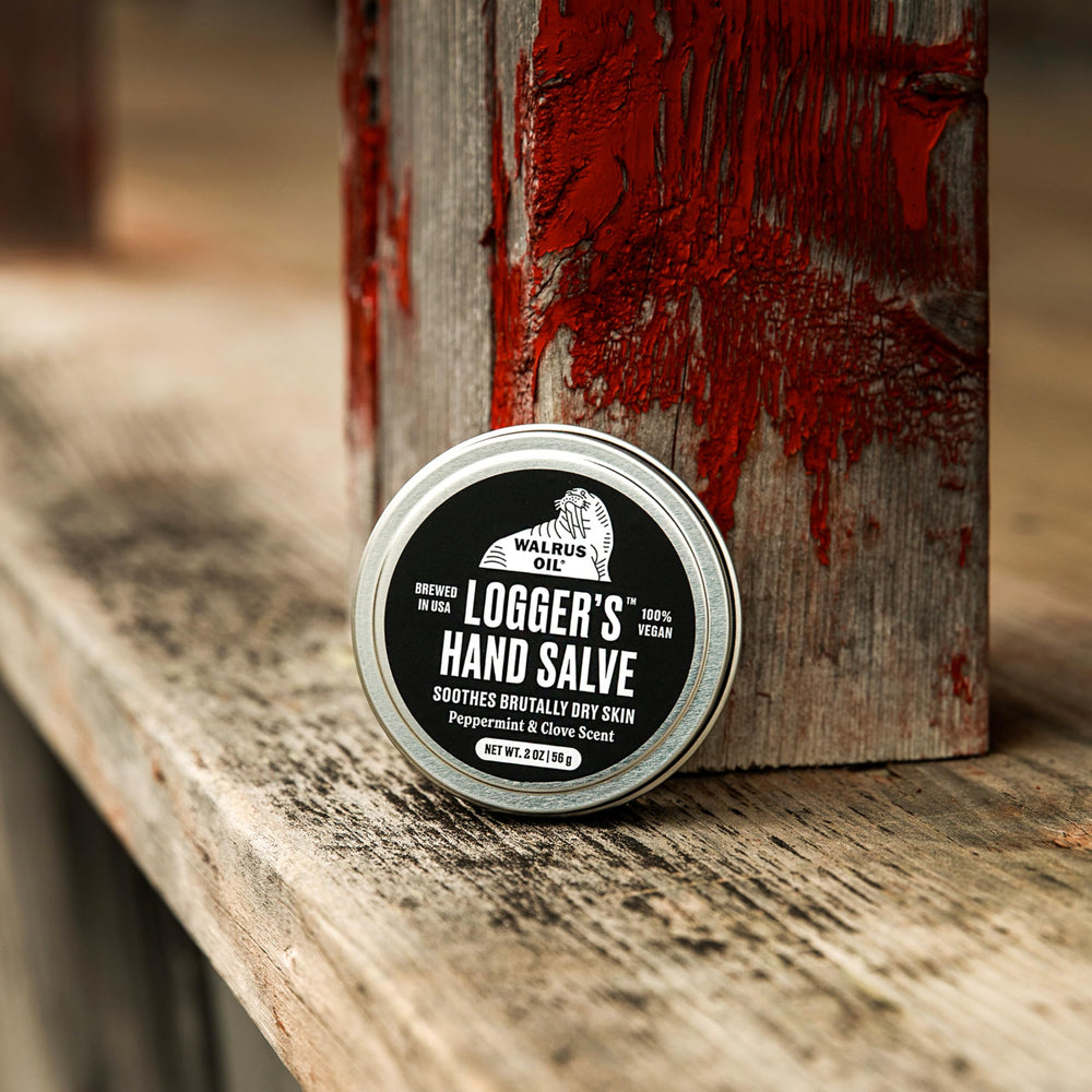 Walrus Oil salve in hand outdoors demonstrating compact size and quick hand care