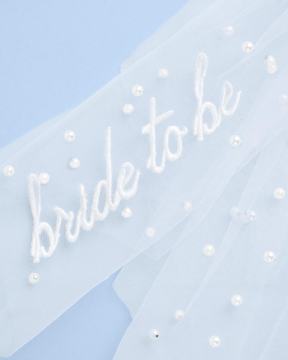 xo, Fetti close-up of tulle texture and scattered pearls adding shimmer
