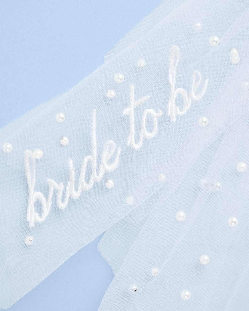 xo, Fetti close-up of tulle texture and scattered pearls adding shimmer