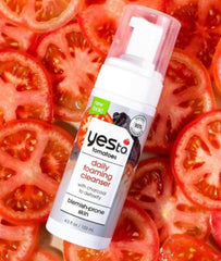 Yes To Tomatoes bottle next to measuring spoon for scale and travel-friendly 4.5 fl oz size