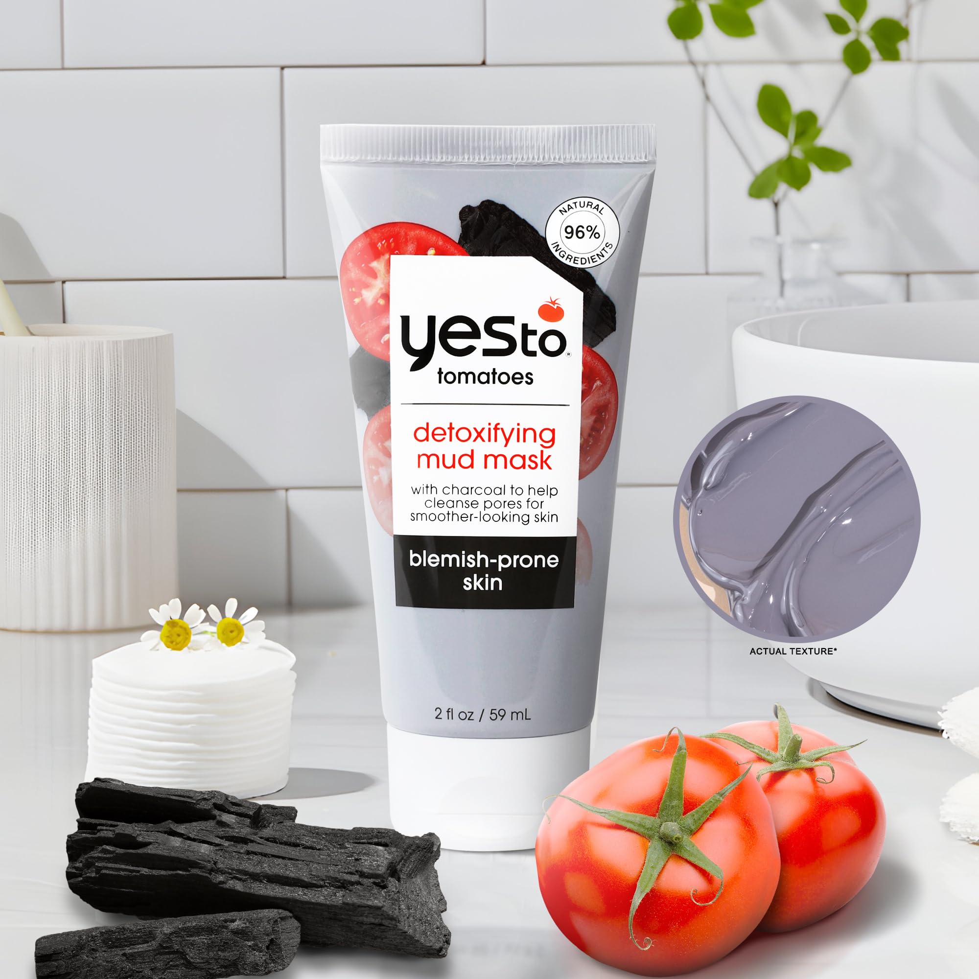 Yes To Tomatoes tube next to a coin showing compact 2.006 oz size for travel convenience