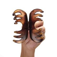 YOUXUAN claw next to hand for scale illustrating 4 inch size and ample hair capacity benefit
