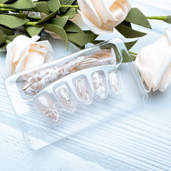 ZASKHLD hands applying press-on nail with adhesive tab for fast secure fit