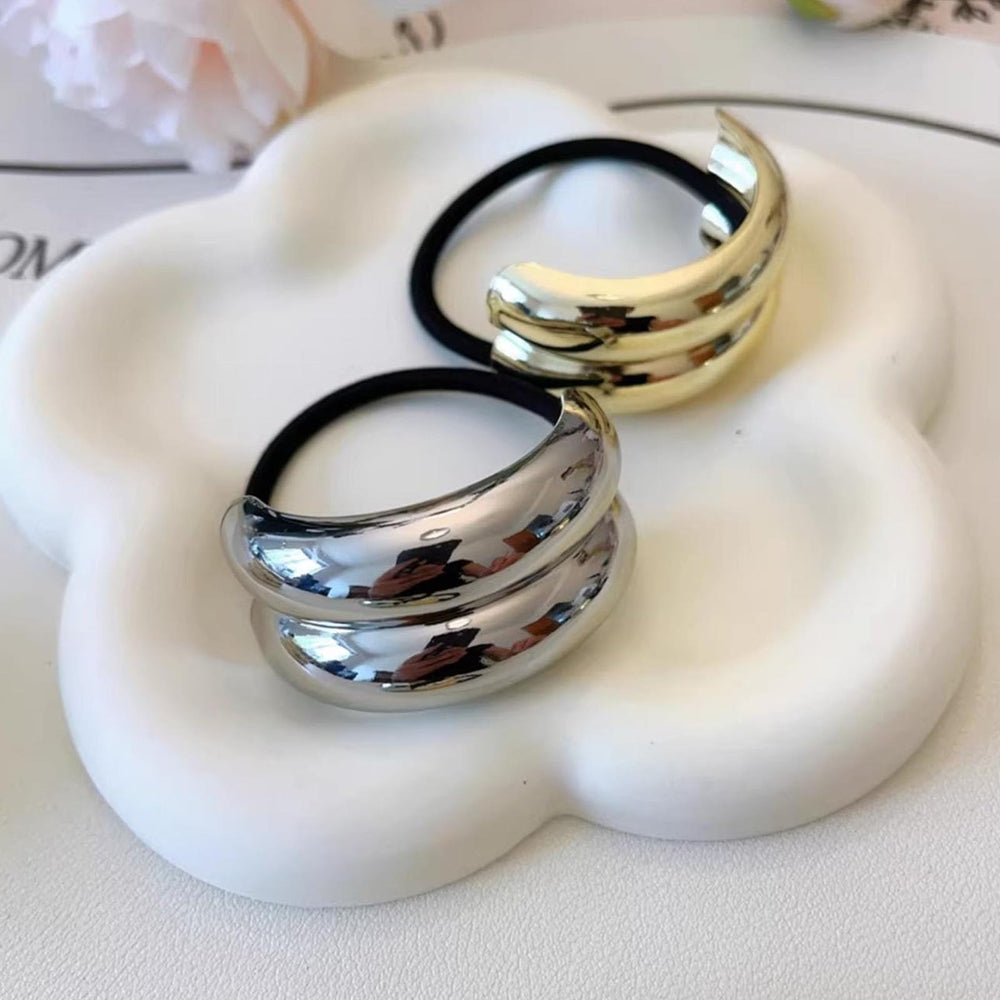 ZEYER metal hair cuff next to coin for scale, compact and travel-friendly convenience