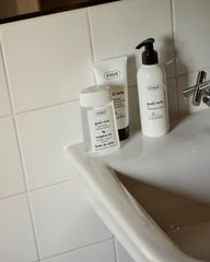 Ziaja 200ml bottle next to hand for size comparison and travel-friendly convenience
